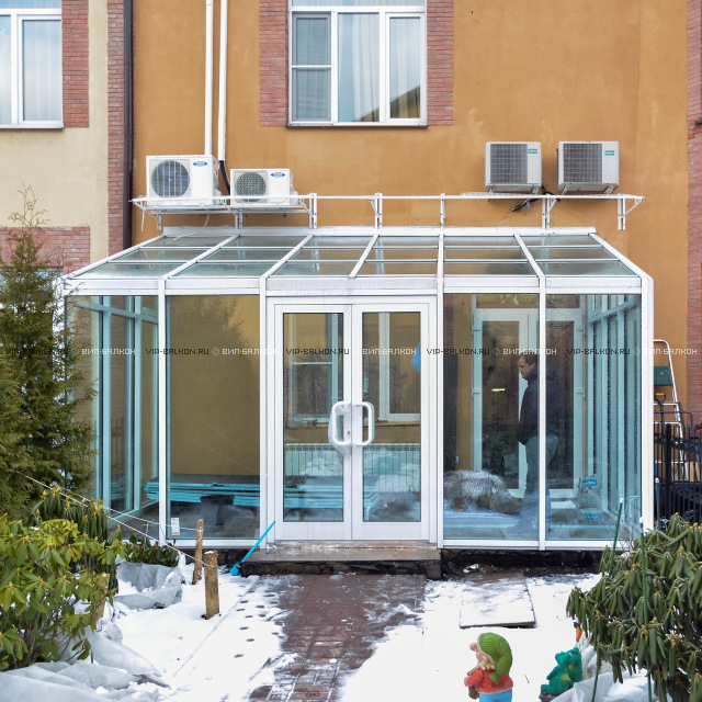 Теплый зимний сад со стеклянной крышей