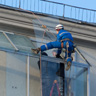 Альпинист помогает установить крышу на балкон